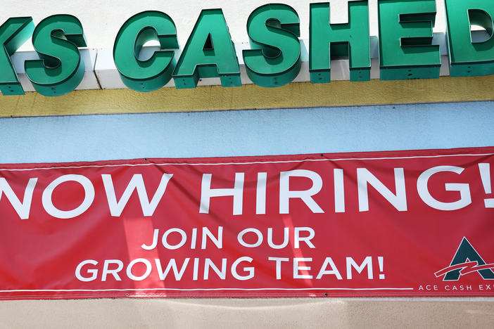 A 'Now Hiring' sign is displayed outside a check cashing shop in Los Angeles on June 2, 2023. Employers added 187,000 jobs in August, while the unemployment rate rose to 3.8%.