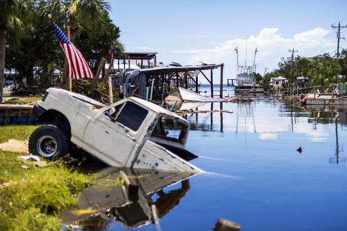 A pick up truck sinks into a canal.