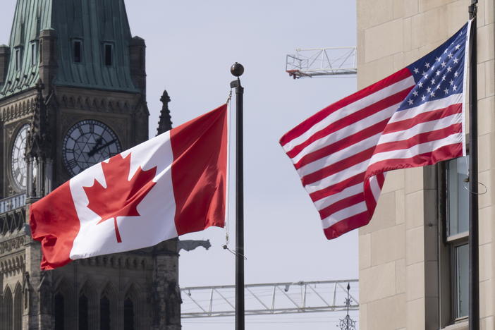 The Canadian and U.S. flags are displayed on lamp posts in the downtown area, March 22, 2023, near Parliament Hill in Ottawa, Ontario.