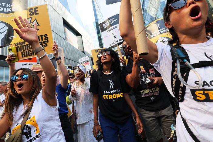 People hold signs as members of SAG-AFTRA and Writers Guild of America East walk a picket line outside of the HBO/Amazon offices during the National Union Solidarity Day in New York City on Aug. 22, 2023. Labor unions have notched some big victories this year but organized labor still faces an uncertain future.