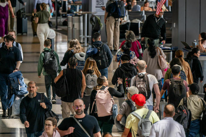 People travel through the Austin-Bergstrom International Airport on Thursday.