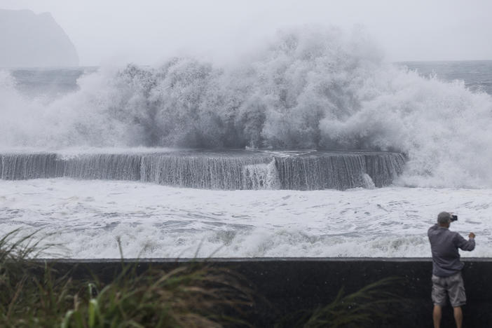 A man takes pictures of huge waves in Yilan as Typhoon Haikui makes landfall in eastern Taiwan on Sunday, Sept. 3, 2023.