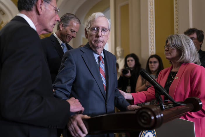 Senate Minority Leader Mitch McConnell, R-Ky., center, is helped by, from left, Sen. John Barrasso, R-Wyo., Sen. John Thune, R-S.D., and Sen. Joni Ernst, R-Iowa, after the 81-year-old GOP leader froze at the microphones on  July 26.