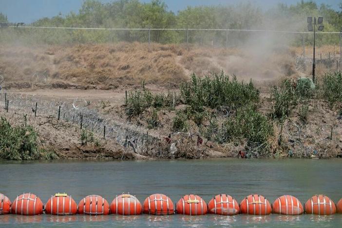 A barrier to deter migrants from crossing from Mexico into the U.S. floats in the Rio Grande at Eagle Pass, Texas.