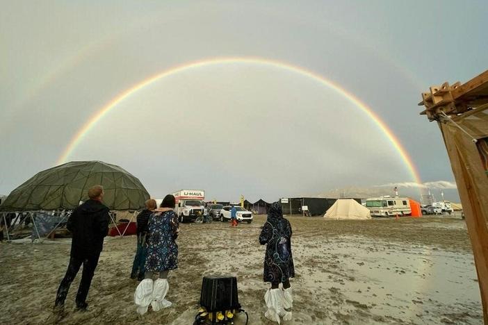 Attendees look at a double rainbow over flooding on a desert plain on Sept. 1, after heavy rains turned the annual Burning Man festival site in Nevada's Black Rock Desert into a mud pit.