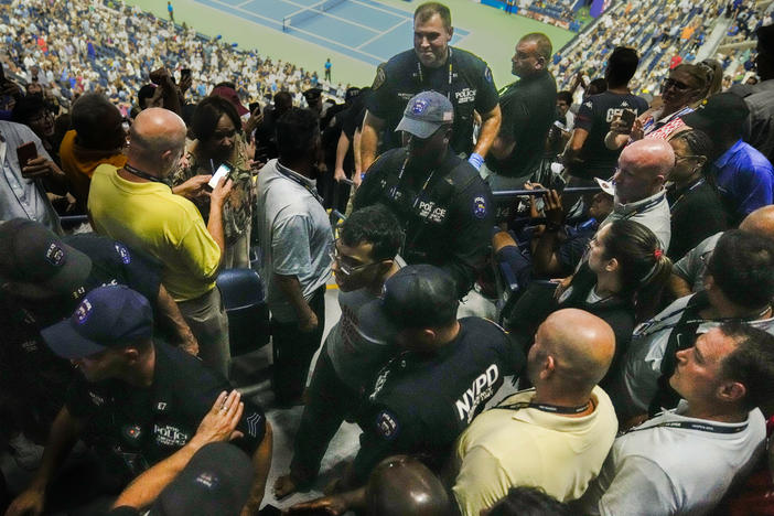 Police officers escort a barefooted protester from the stands during a match between Coco Gauff and Karolina Muchova in the women's singles semifinals of the U.S. Open tennis championships, Thursday, Sept. 7, 2023, in New York.