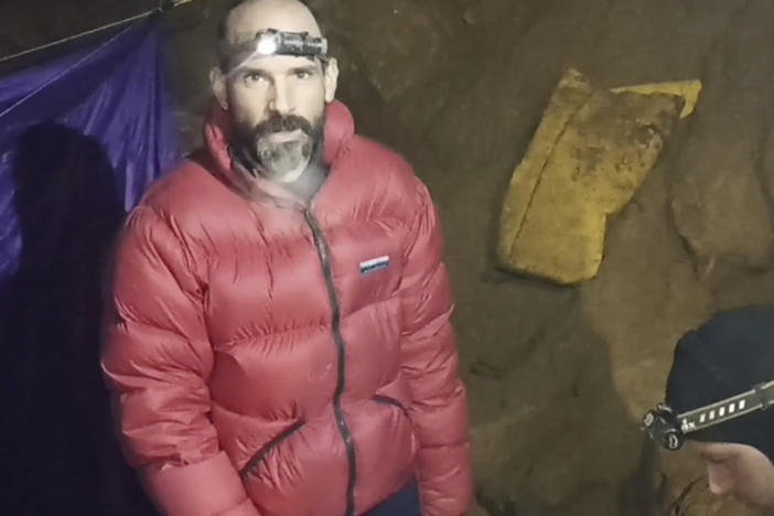 In this screen grab from video, American caver Mark Dickey, 40, talks to camera next to a colleague inside the Morca cave near Anamur, southern Turkey, Thursday, Sept. 7, 2023. Turkish and international cave rescue experts are working to save an American speleologist trapped at a depth of more than 1,000 meters (3,280 feet) in a cave in southern Turkey after he became ill.