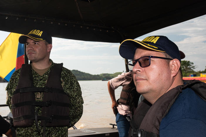 Mayor Edilberto Molina (right), alongside Lt. Col. Óscar Usme aboard a well-armed Colombian Navy boat, tour the Caguán River which flows past Cartagena del Chairá.