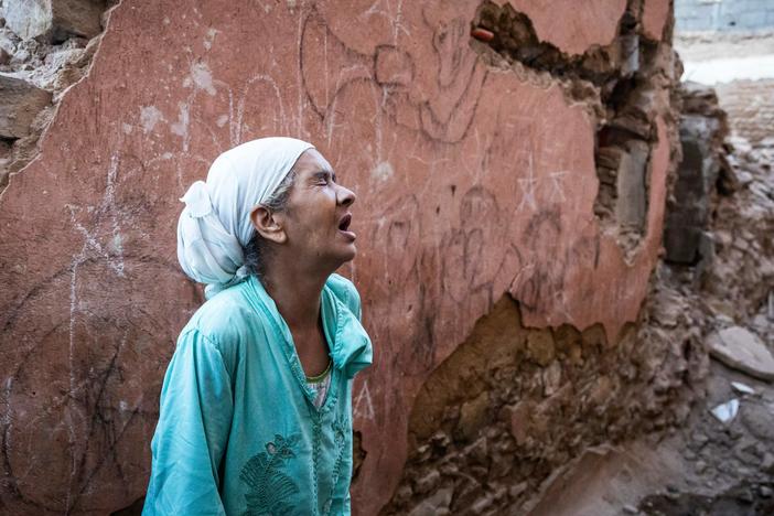 A woman reacts standing in front of her earthquake-damaged house in the old city in Marrakesh.