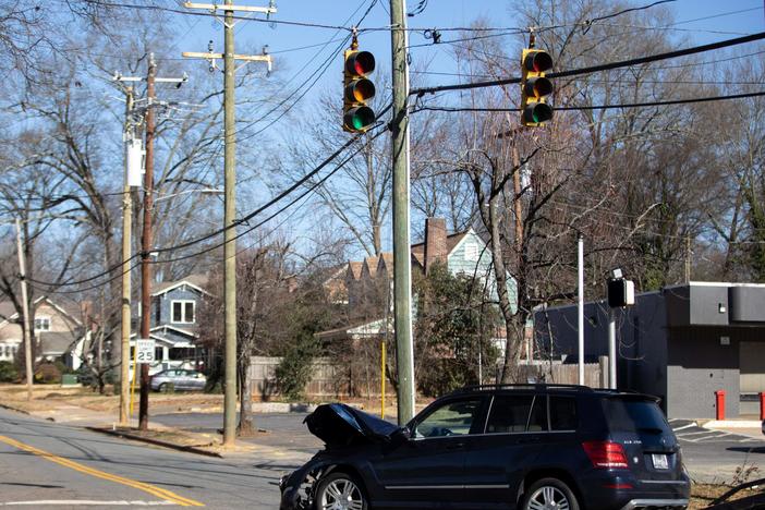 A car accident is cleared at an intersection without power in Charlotte, N.C., on Dec. 24, 2022. Auto insurance costs are soaring — well outpacing overall inflation.
