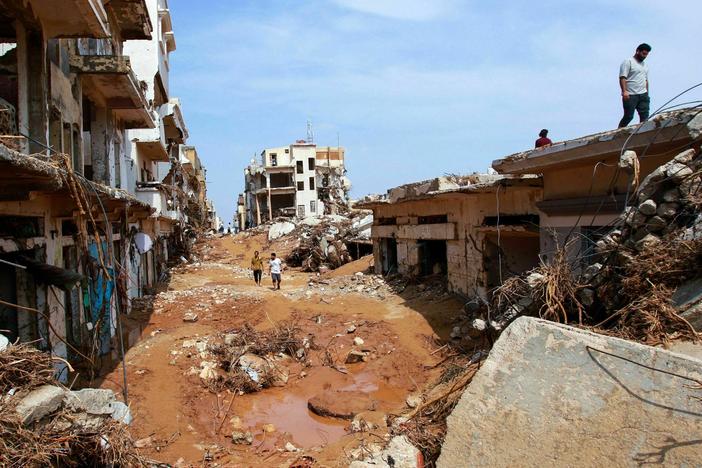 People check an area damaged by flash floods in Derna, eastern Libya, on Monday.