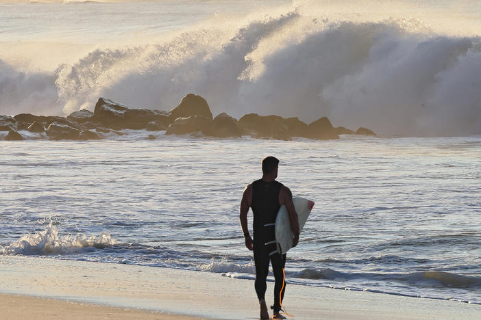 A surfer watches higher than normal waves crash ashore in Lido Beach, N.Y. on Thursday, Sept. 14, 2023. Long Island beaches witnessed 8 to 10-foot waves as Hurricane Lee moved toward the New England area.