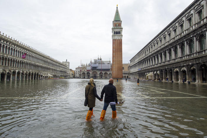 A couple walks in a flooded Saint Mark's Square during high waters on Nov. 19, 2013, in Venice, Italy.