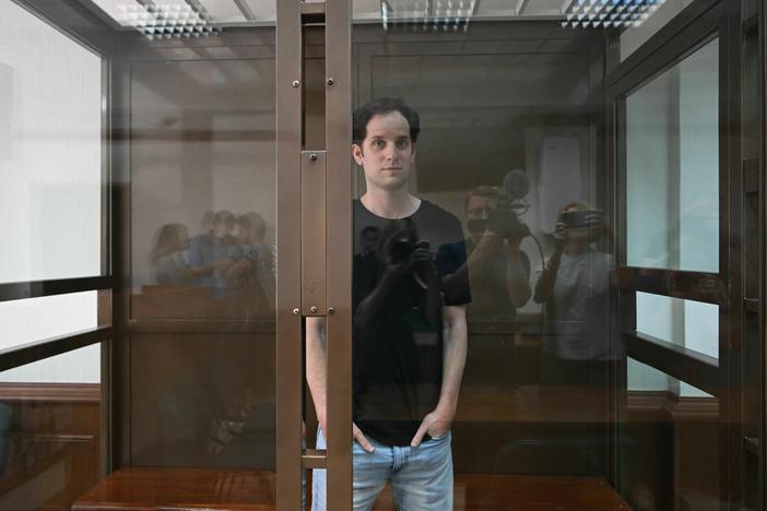 Evan Gershkovich stands inside a defendants' cage before a June hearing in Moscow.