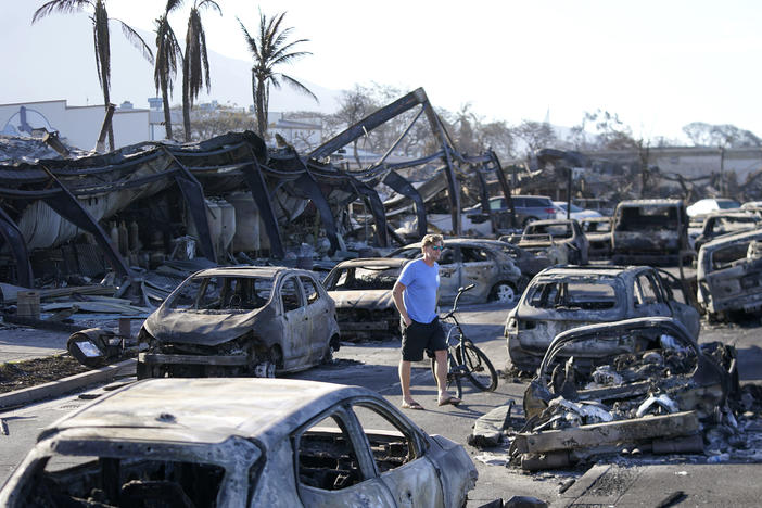 A man walks through wildfire wreckage Aug. 11, in Lahaina, Hawaii.