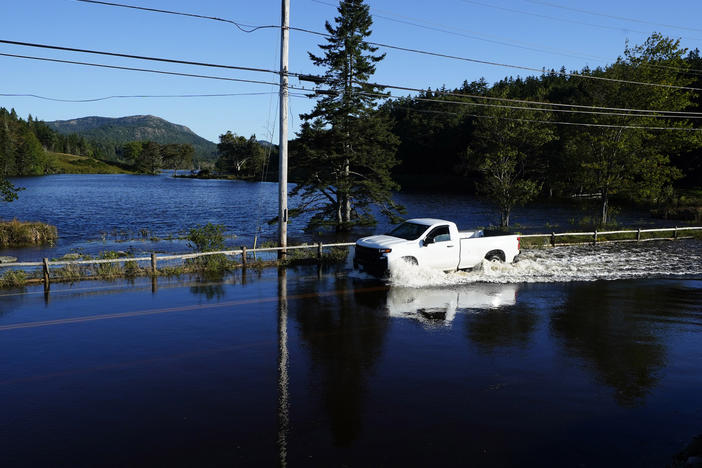 A motorist travels through floodwaters on a road that remains closed a day after Atlantic storm Lee passed through the region, on Sunday, Sept. 17, 2023, near Northeast Harbor, Maine.