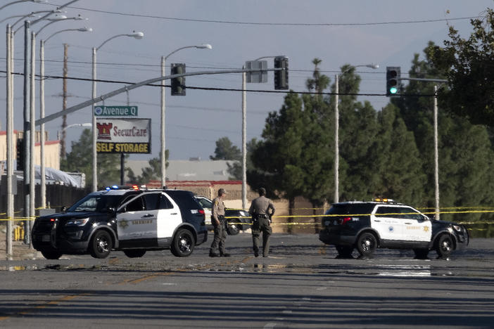 Police cars block off a street where a sheriff's deputy was shot while in his patrol car in Palmdale, Calif. on Sunday, Sept. 17, 2023.