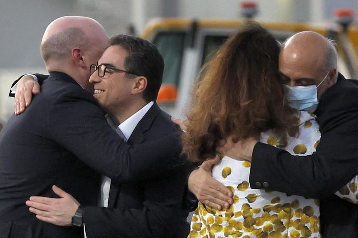 Siamak Namazi (second left) and Morad Tahbaz (right) are welcomed after disembarking from a Qatari jet on their arrival at the Doha International Airport on Monday.