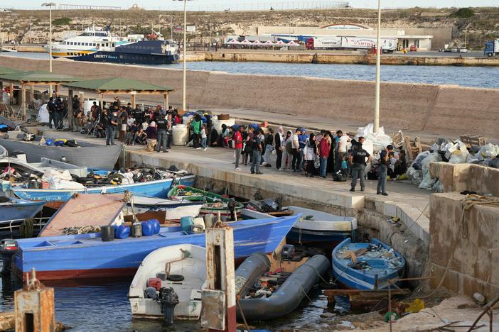 Migrants wait at the port after arriving on the Italian island of Lampedusa, on Monday, Sept. 18, 2023. Italy unveiled tough rules to deter migrants after record boat crossings from North Africa to Lampedusa saw the country's southernmost tip overwhelmed with new arrivals.