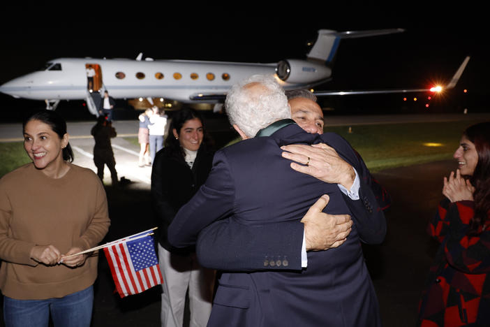Family members embrace freed Americans Siamak Namazi, Morad Tahbaz and Emad Shargi, as well as two returnees whose names have not been released by the U.S. government, who were released in a prisoner swap deal between U.S and Iran, as they arrive at Davison Army Airfield on Tuesday at Fort Belvoir, Va.