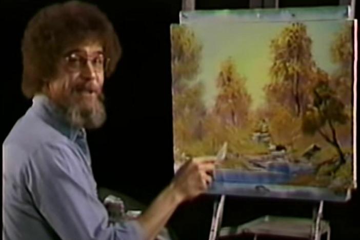 A screenshot from the premiere of <em>The Joy of Painting</em> shows the painter Bob Ross with the work, A Walk in the Woods, which is up for sale.