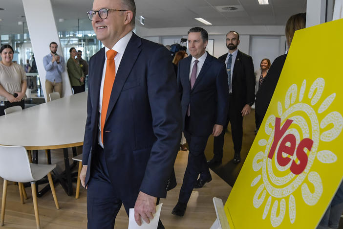 Australian Prime Minister Anthony Albanese, foreground, walks past a "Yes" sign, referring to upcoming referendum, as he arrives for a press conference at South Australian Health and Medical Research Institute in Adelaide, Thursday, Sept. 21, 2023.
