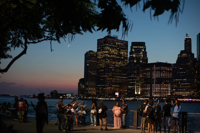 Trees and other plants help keep cities cooler. In New York City, scientists are working to understand how to maximize the benefits of urban green spaces. Here, residents gather in Brooklyn Bridge Park on a hot summer night.
