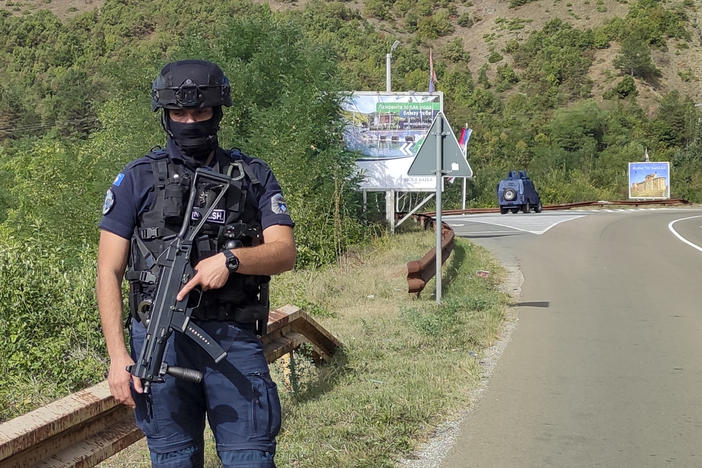 A Kosovo police officer guards the road near the village of Banjska, 55 kilometers (35 miles) north of the capital Pristina, northern Kosovo, Sunday, Sept. 24, 2023. Prime Minister Albin Kurti on Sunday said one police officer was killed and another wounded in an attack he blamed on support from neighboring Serbia, increasing tensions between the two former war foes.