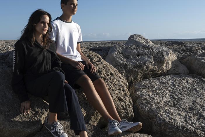 Siblings Sofia Oliveira, 18, and Andre Oliveira, 15, pose for a picture at the beach in Costa da Caparica, south of Lisbon, Wednesday, Sept. 20, 2023.