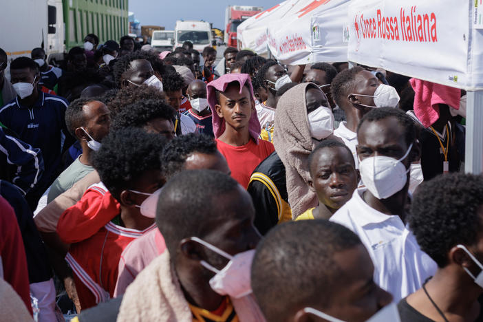 Migrants in Lampedusa's Porto Vecchio wait to be transferred by ferry to Porto Empedocle, from where they will be sent to reception centers across the country, Sept. 22. Most of them arrived in the previous week, a period when Lampedusa declared a state of emergency due to an influx of about 7,000 migrants in a few days.