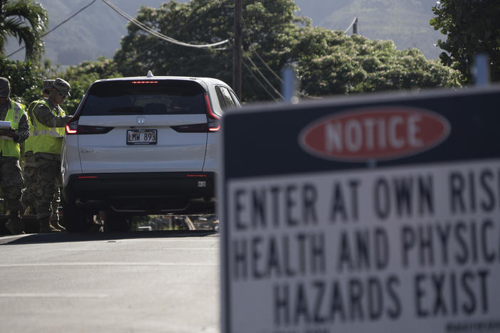The Hawaii National Guard checks on a car passing the checkpoint on Kaniau Street on Monday, Sept. 25, 2023, in Lahaina, Hawaii.