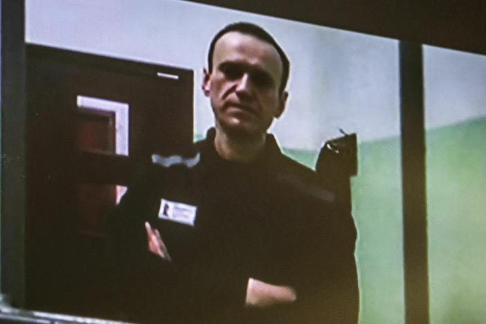 A screen in a Moscow courtroom shows jailed Kremlin critic Alexei Navalny as he arrives to listen to a hearing via video on Tuesday. An appeals court has upheld his 19-year prison sentence.