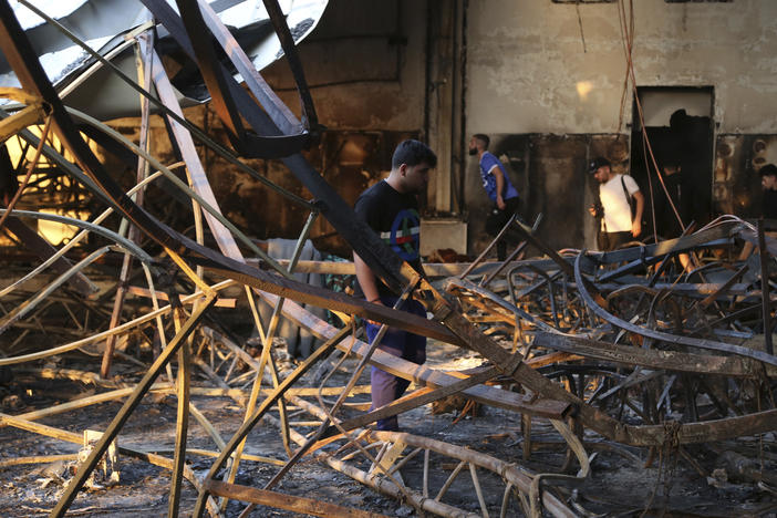 People gather at the site of a fatal fire, in the district of Hamdaniya, Nineveh province, Iraq, on Wednesday, Sept. 27, 2023.