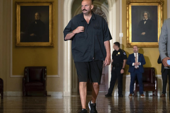 Sen. John Fetterman, D-Pa., walks on Capitol Hill on Thursday. He says he will continue to wear a suit on the Senate floor in compliance with the newly codified dress code.