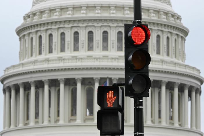 A stoplight is seen in front of the dome of the U.S. Capitol in Washington, D.C., on Thursday. The government has begun to inform workers of an impending shutdown that could see millions of federal employees and military personnel sent home or working without pay.