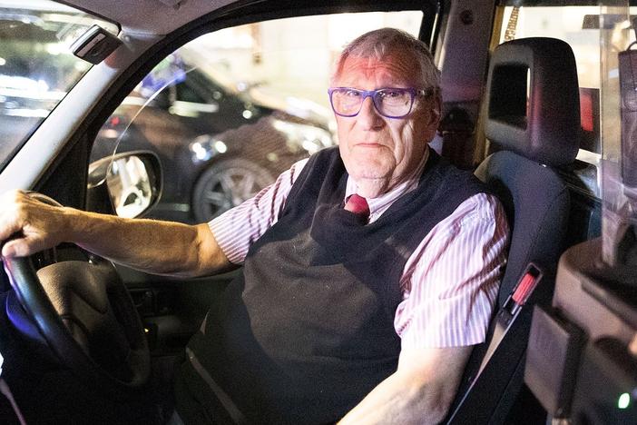 Michael Son sits behind the wheel in his London cab, a job he's had since 1965.