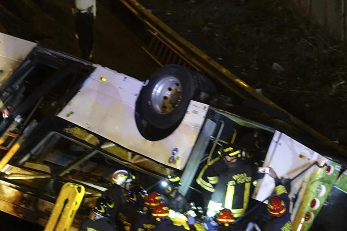 Emergency services personnel work at the scene of a passenger bus crash that killed 21 people and injured at least 15 others in Venice, Italy, on Tuesday night.