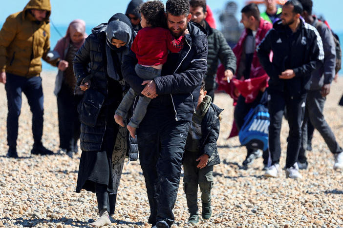 People believed to be migrants walk in Dungeness, a headland on the coast of England, on Aug. 16.