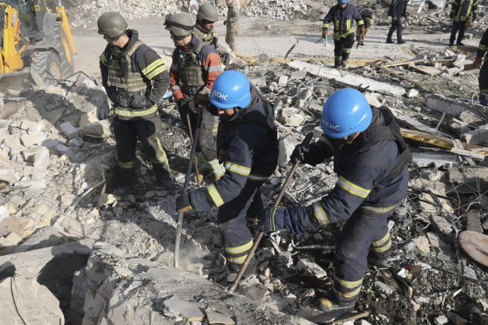 In this photo provided by the Ukrainian Presidential Press Office, emergency workers search the victims of the deadly Russian rocket attack that killed dozens of people in the village of Hroza near Kharkiv, Ukraine, Thursday, Oct. 5, 2023.