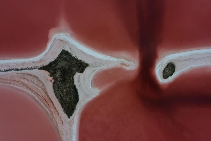 Evaporation ponds that are pinkish-red due to high salinity levels are visible on the north section of the Great Salt Lake in August 2021 near Corinne, Utah.