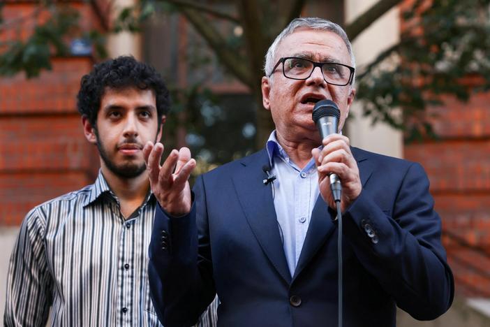 Iranian journalist Taghi Rahmani, husband of Iranian rights campaigner and 2023 Nobel Peace Prize laureate Narges Mohammadi, speaks, flanked by their son Ali, during a press conference in Paris on October 6, 2023.