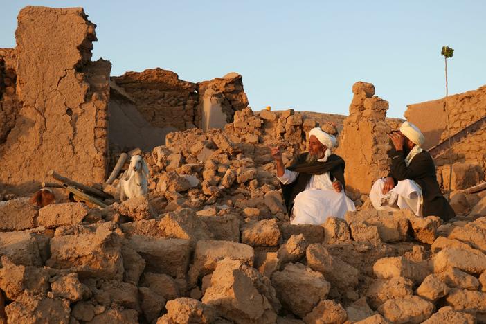 Afghan residents sit at a damaged house after an earthquake in a village in Herat province on Saturday.