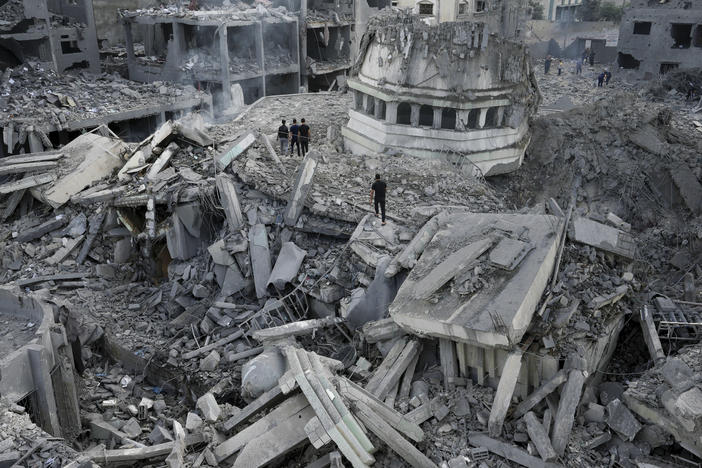 Palestinians inspect the rubble of the Yassin Mosque, destroyed after it was hit by an Israeli airstrike at Shati refugee camp in Gaza City, early Monday. Israel's military battled to drive Hamas fighters out of southern towns and seal its borders Monday as it pounded the Gaza Strip.