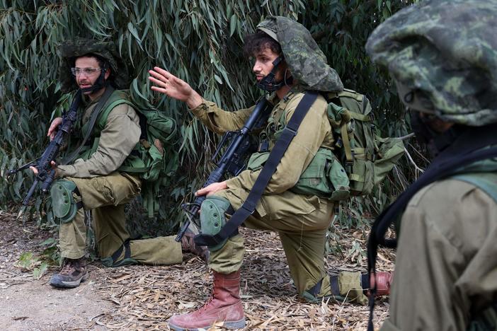 Israeli soldiers take up position in Kfar Aza, in the south of Israel, bordering Gaza Strip on Tuesday, Oct. 10, 2023.