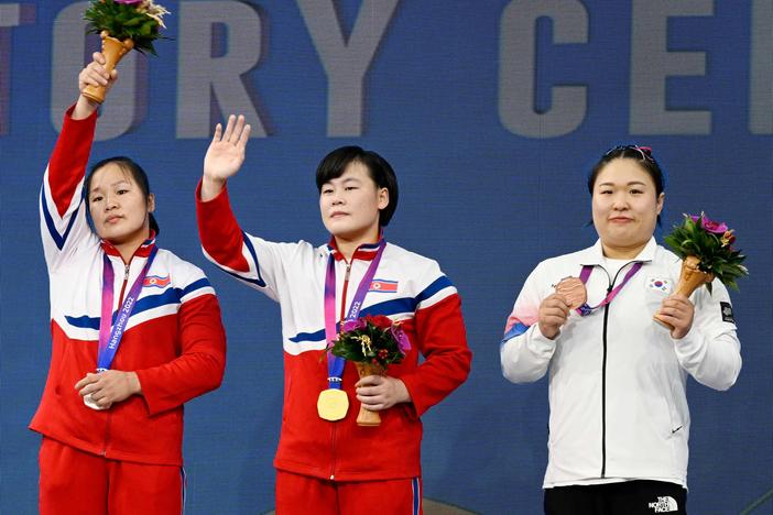 Gold medalist North Korea's Song Kukhyang, center, silver medalist North Korea's Jong Chunhui, left, and bronze medalist South Korea's Kim Suhyeon, right, gesture during the medal ceremony of women's 76kg group A weightlifting competition at the 2022 Asian Games in Hangzhou, China, on Oct. 5, 2023.