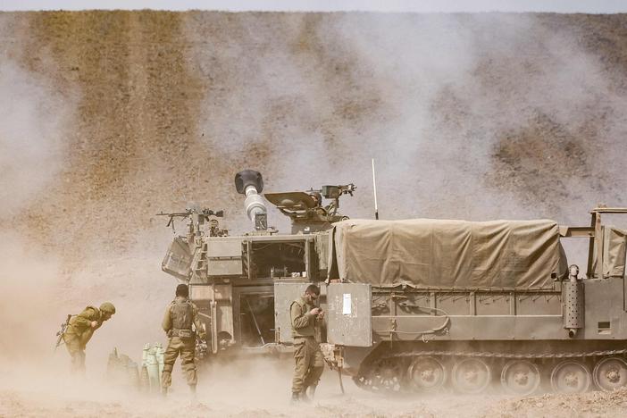 An Israeli army self-propelled howitzer fires rounds near the border with Gaza in southern Israel on Oct. 11.