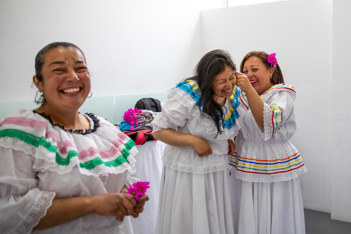 Ruth Infante (second from left), a single mother of three, and her classmates donned traditional flowing dresses for their <em>Cumbia</em> dance performance at a "care block" center in Bogotá, Colombia. The class is one of the free services offered to anyone in the neighborhood who is an unpaid caregiver for their family.