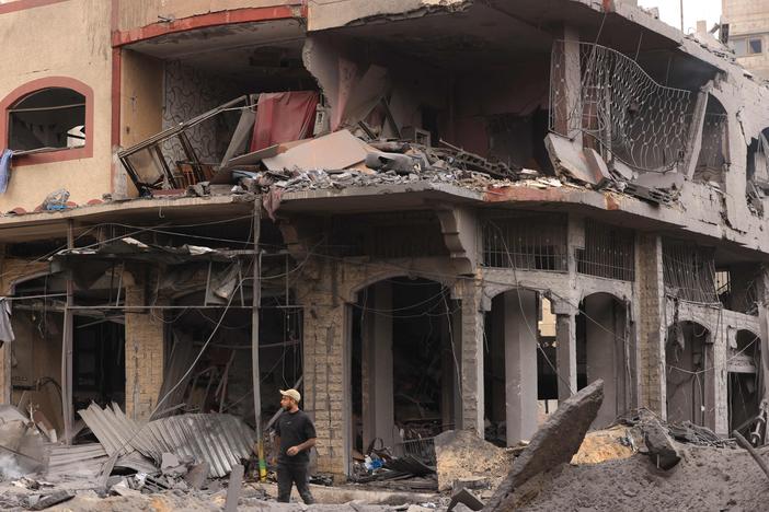 A young Palestinian walks through rubble in a heavily bombarded neighborhood following overnight Israeli airstrikes on Gaza City's Shati refugee camp early on Monday.