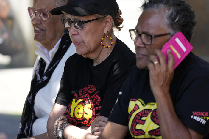 Indigenous women sit on a bench at a polling place in Sydney as Australians cast their final votes in the referendum to create an Indigenous advocacy committee to Parliament.