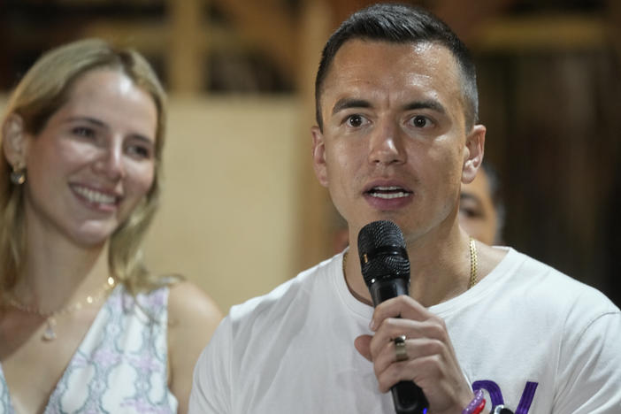 Presidential candidate Daniel Noboa speaks in Olon, Ecuador, after results show him ahead in a snap presidential runoff on Sunday, Oct. 15, 2023. At left is his wife Lavinia Valbonesi.